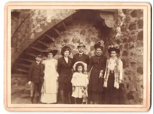 Fotografie Fotograf und Ort unbekannt, Familie in bester Sonntagsbekleidung in einem Keller-Gewölbe