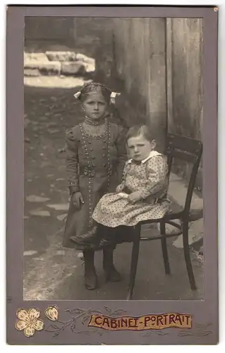 Fotografie unbekannter Fotograf und Ort, niedliches Mädchen mit Zöpfen mit Geschwisterchen im Hof