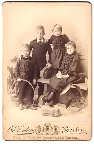 Fotografie Otto Lindner, Berlin, Königstrasse 30, Portrait zwei Jungen und zwei Mädchen in hübscher Kleidung mit Reifen