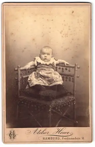 Fotografie Atelier Howe, Hamburg, Ferdinandstrasse 51, Portrait niedliches Baby im hübschen Kleid auf Kissen sitzend