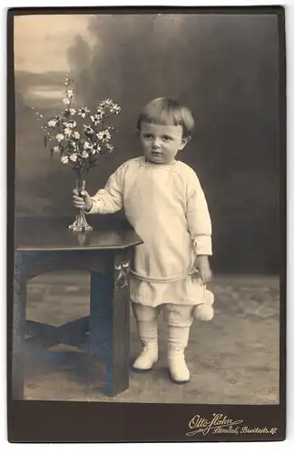 Fotografie Otto Hahn, Stendal, Breitestrasse 87, Portrait kleiner Junge in weisser Kleidung mit Blumen