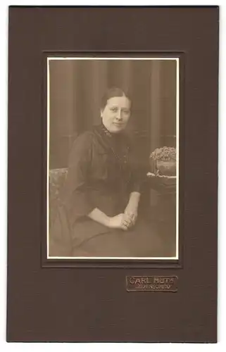 Fotografie Carl Huth, Lüdenscheid, Portrait schwarz gekleidete Dame auf Stuhl sitzend