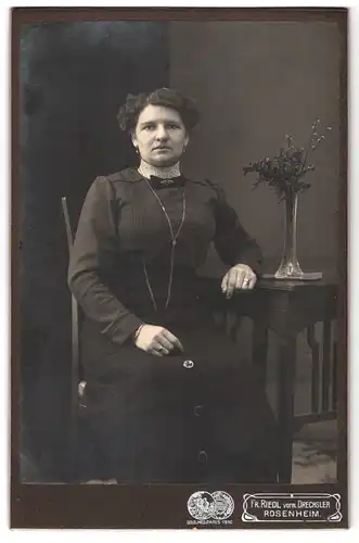 Fotografie Fr. Riedl, Rosenheim, Heiligengeist-Stollstrasse 8, Portrait modisch gekleidete Dame am Tisch sitzend