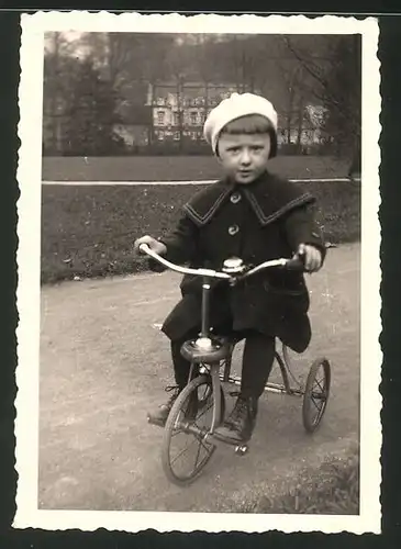 Fotografie Mädchen fährt auf Dreirad