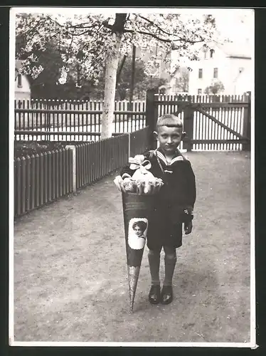 Fotografie Einschulung, Knabe in Marineuniform mit Zuckertüte