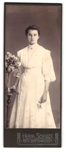 Fotografie Herm. Schulze, Bischofswerda, Portrait junge Dame im weissen Kleid mit Blume