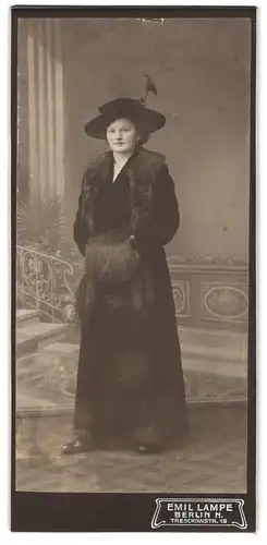 Fotografie Emil Lampe, Berlin, Tresckowstr. 18, Dame mit Hut und Pelzmuff trägt schwarzes Kleid
