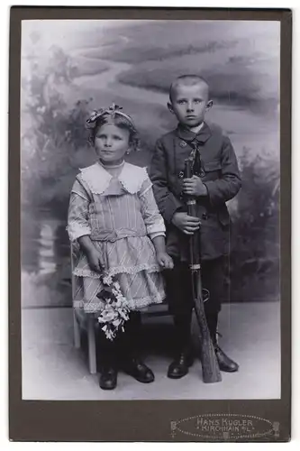 Fotografie Hans Kugler, Kirchhain N / L., Portrait Junge und Mädchen im Kleid mit Spielzeuggewehr