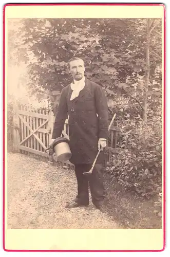 Fotografie unbekannter Fotograf und Ort, Kutscher in langem Mantel mit Zylinder und Stock
