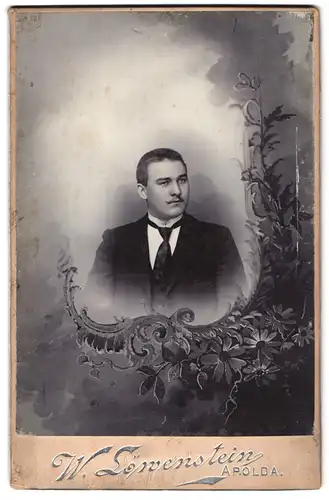 Fotografie W. Löwenstein, Apolda, Portrait junger Mann im Anzug mit Krawatte, Passepartout