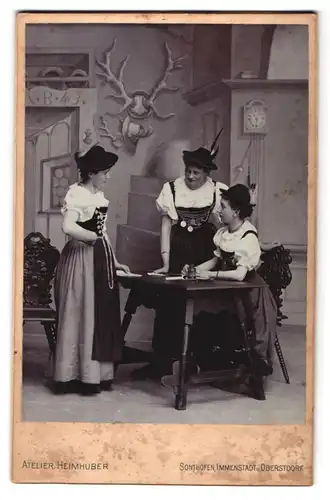 Fotografie Atelier Heimhuber, Sonthofen, Immenstadterstr.Portrait drei Damen in bayrischer Tracht am Schreibtisch