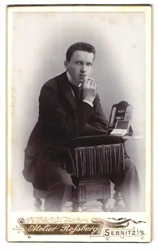 Fotografie Rossberg, Sebnitz i. S., junger Mann sitzt mit Zigarette auf einem Stuhl