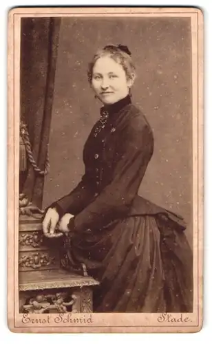 Fotografie Ernst Schmid, Stade, Junge hübsche Frau in gewaltigem Kleid mit zurückgebundenen Haaren