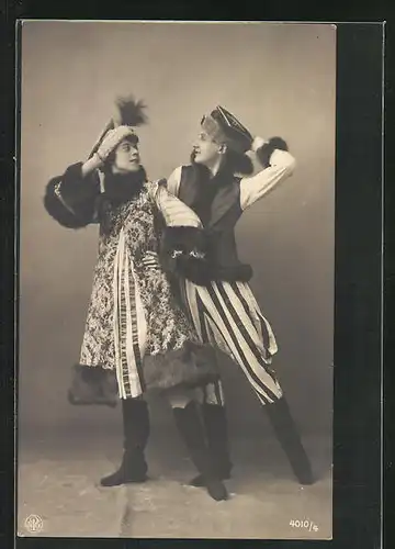 AK Frau in ausgestelltem Pelzmantel und Mann in gestreifter Hose tanzen Volkstanz