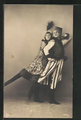 AK Frau in gemustertem Pelzmantel tanzt mit Mann in gestreifter Hose einen Volkstanz