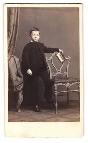 Fotografie A. Kindermann, Hamburg, Theaterstrasse 7, Portrait Junge im schwarzen Anzug mit Buch in der Hand