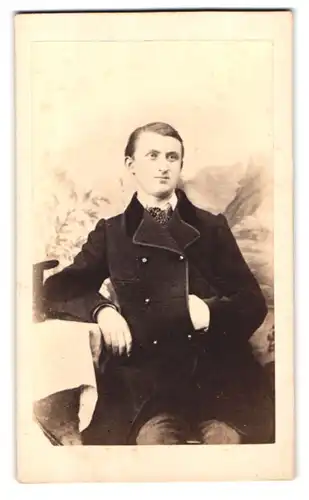 Fotografie A. Herbst, Pyrmont, Brunnestr. Portrait junger Mann im schwarzen Stoffmantel in Napoleon Pose