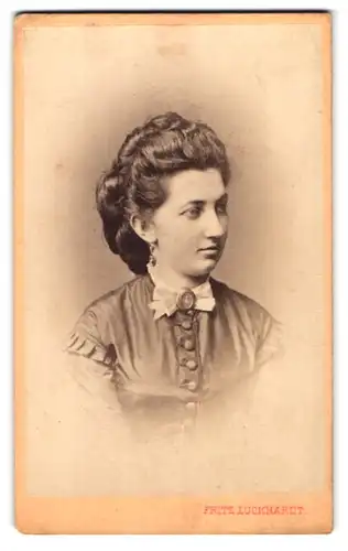 Fotografie Fritz Luckhardt, Leopoldstadt, Portrait junge Frau mit Zöpfen im Kleid, Brosche