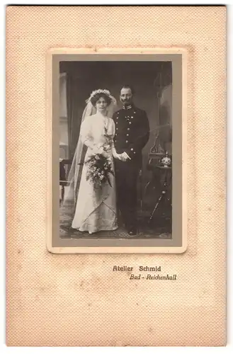 Fotografie Atelier Schmid, Bad-Reichenhall, Portrait Beamter in Uniform mit Pickelhaube und Säbel nebst Braut