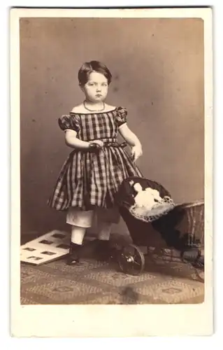 Fotografie A. Kindermann, Hamburg, Theaterstr. 2, Portrait kleines Mädchen im karierten Kleid mit Puppe und Puppenwagen