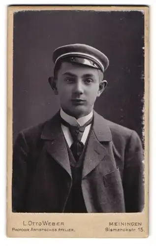 Fotografie L. Otto Weber, Meiningen, Bismarckstr. 15, Portrait junger Student im Anzug mit Tellermütze und Segelohren