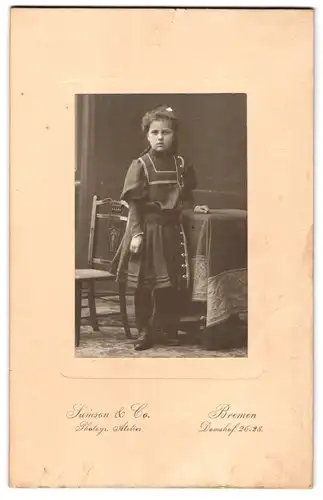 Fotografie Samson & Co., Bremen, Domshof 26-28, Mädchen im schwarzen Kleid mit Hand auf Beistelltisch