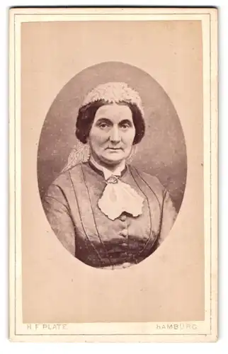 Fotografie H. F. Plate, Hamburg, Jungfernstieg 14, Portrait betagte Dame mit Rüschenhaube und Brosche am Kragen