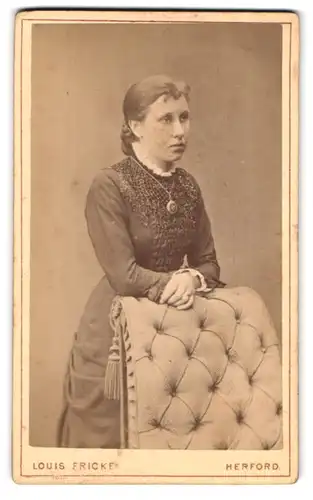 Fotografie Louis Fricke, Herford, Bäckerstr. 677, Portrait charmantes Fräulein mit Amulettkette in besticktem Kleid