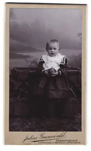 Fotografie Julius Grunewald, Oberneukirch, Portrait süsses Kleinkind hält einen Ball in der Hand