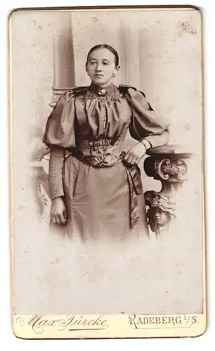 Fotografie Max Türcke, Radeberg i. S., Langestr. 1, Portrait charmante Dame mit Brosche und Halskette im Kleid
