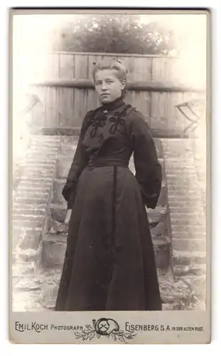 Fotografie Emil Koch, Eisenberg / S.-A., in der alten Post, Portrait blonde hübsche Dame im Garten stehend