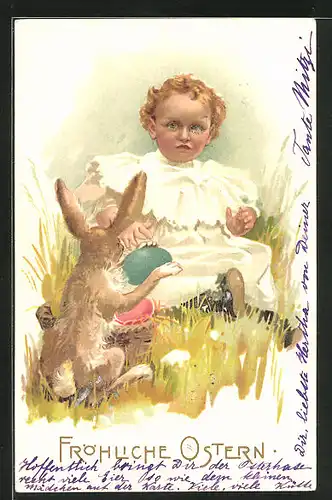 AK niedliches Mädchen sitzt mit einem Osterhasen und bunten Eiern im Gras