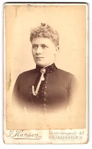 Fotografie J. Hansen, Kopenhagen, Vesterbrogade 43, Portrait blonde Dame mit lockigem Haar und Brosche am Kragen