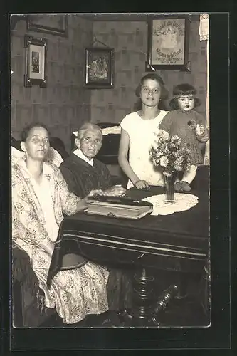 AK drei Damen mit Fotoalbum und Puppe am Tisch