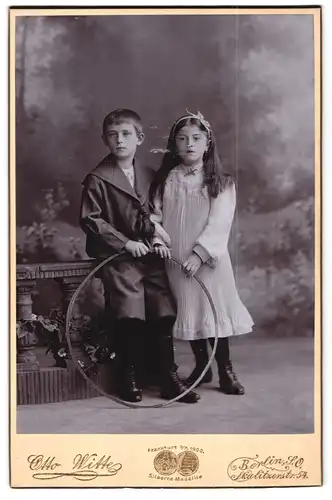 Fotografie Otto Witte, Berlin-SO, Skalitzer-Strasse 54, Portrait Kinderpaar in hübscher Kleidung mit Reifen