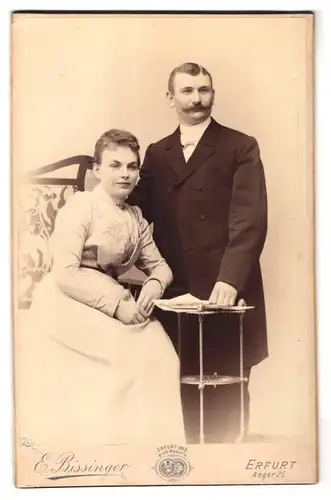 Fotografie E. Rissinger, Erfurt, Anger 25, Paar in eleganter Kleidung mit Zeitung auf dem Beistelltisch