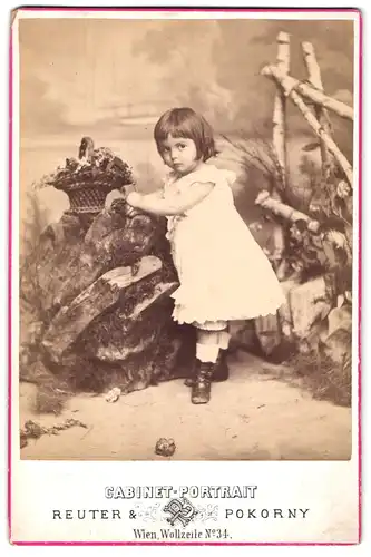 Fotografie Reuter & Pokorny, Wien, Wollzeile 34, Cabinet-Portrait kleines Mädchen im weissen Kleid mit Blumenkorb