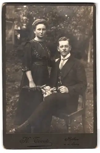 Fotografie K. Tovote, Rethen a. d. Leine, Portrait junges Paar in hübscher Kleidung mit Blumenstrauss