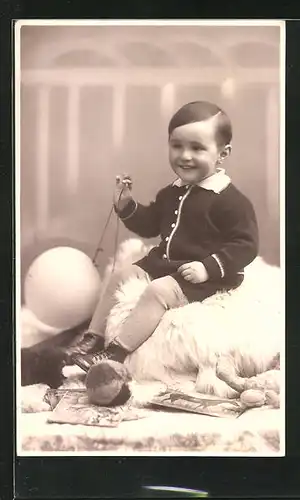 Foto-AK Knabe mit Ball an Schnurr, Spielzeug