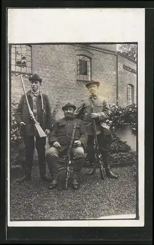 Foto-AK Drei Jäger mit Gewehren vor einem Gebäude