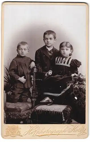 Fotografie J. F. Kolby, Chemnitz, König-Strasse 21, Portrait zwei kleine Jungen und Mädchen in modischer Kleidung