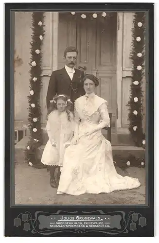 Fotografie Julius Grunewald, Oberneukirch, Portrait bürgerliches Paar und Tochter in eleganter Kleidung