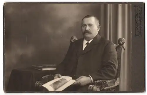 Fotografie Adolf Nöthel, Hannover-Linden, Deisterstrasse 1, Portrait bürgerlicher Herr im Anzug mit einem Heft