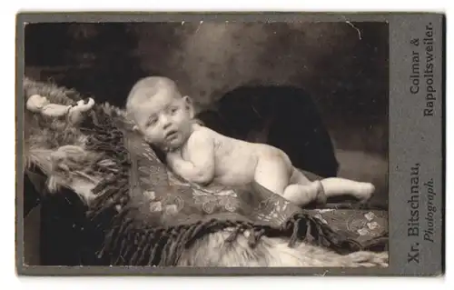 Fotografie Xr. Bitschnau, Colmar, Portrait nackiges Baby bäuchlings auf Decke sitzend