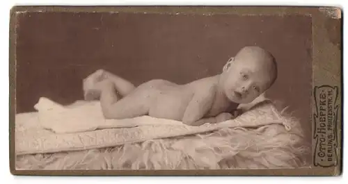 Fotografie Otto Hoeffke, Berlin-S, Prinzenstrasse 11, Portrait nackiges Baby bäuchlings auf Decke liegen
