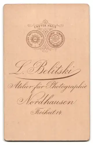 Fotografie L. Belitski, Nordhausen, Freiheit 14, Portrait kleines Mädchen im karierten Kleid auf Sessel sitzend