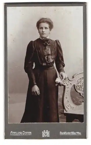 Fotografie Atelier Osten, Berlin, Frankfurter Allee 109-12, Portrait bürgerliche Dame mit Blume an Bank gelehnt