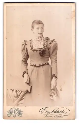 Fotografie Osw. Schmidt, Mügeln, Bismarckstrasse, Portrait junge Dame im modischen Kleid mit Blume