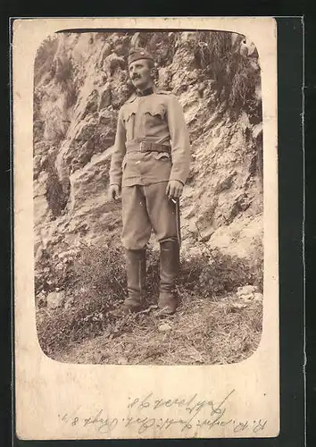 AK österreichischer Soldat in Uniform vor einer Felswand stehend