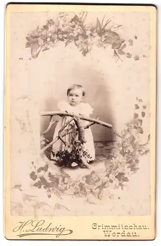 Fotografie H. Ludiwg, Crimmitschau, Portrait kleines Kind im weissen Kleid lehnt an Holzgeländer